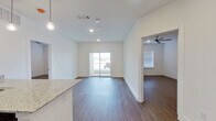 This thoughtfully designed 2-bedroom, 2-bathroom single-story residence offers a clean, contemporary aesthetic throughout. The open-concept kitchen and living area forms the heart of the unit, where dark espresso cabinetry contrasts elegantly with light granite countertops. A peninsula with pendant lighting provides additional workspace and casual seating, while stainless steel appliances—including a refrigerator, range, and microwave—complete the well-appointed kitchen. Hardwood-style flooring runs consistently throughout the unit, adding warmth and visual continuity.

The living area is bright and welcoming, benefiting from recessed lighting and a sliding glass door that introduces natural light and provides outdoor access. Both bedrooms are comfortably proportioned, each equipped with ceiling fans and windows fitted with blinds. The primary bedroom connects directly to an en-suite bathroom featuring a double vanity with granite countertops, dark cabinetry, a large mirror, and a tiled walk-in shower. A dedicated walk-in closet with wire shelving provides practical storage. The second bathroom mirrors the same refined finishes. Crisp white walls and clean trim throughout lend the space a fresh, move-in-ready quality.