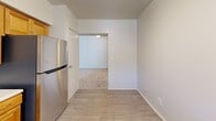 Located at 1239 Washington St in Whitehall, PA, this single-floor unit offers four bedrooms and two full bathrooms within a well-organized and functional layout. The kitchen is outfitted with warm honey-toned wood cabinetry, white countertops, stainless steel appliances including a dishwasher and refrigerator, and a gas range. Light wood-style flooring runs throughout the kitchen and adjoining areas, lending a clean, cohesive feel. The kitchen opens toward a carpeted living area, creating an easy flow between spaces. Each of the four bedrooms features neutral wall tones, plush carpet flooring, and natural light from windows dressed with blinds. Several bedrooms include built-in closets with louvered bifold doors, providing practical storage solutions. The primary bedroom is generously proportioned, offering ample space for a full furniture arrangement. Both bathrooms are equipped with tub-shower combos. The unit is part of a multi-story residential building surrounded by mature trees and well-maintained green landscaping, with a parking area and balconies visible from the exterior. The overall ambiance is clean, neutral, and move-in ready.