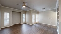 This 1-bedroom, 1-bathroom residence is designed for comfortable, efficient living, featuring a cohesive layout across a single floor. The open living area is finished with durable wood-look flooring, crown molding, and a ceiling fan with integrated lighting, creating a bright and welcoming atmosphere. Multiple windows fitted with blinds allow natural light to fill the space throughout the day. The kitchen is a functional galley-style design showcasing granite countertops, crisp white cabinetry with modern hardware, a stainless steel sink, and stainless steel appliances including a range, microwave, and dishwasher. A peninsula with a granite surface connects the kitchen to the living area, offering additional prep or casual dining space. The bedroom features plush wall-to-wall carpeting, a ceiling fan, and a generously sized window that brings in natural light. A dedicated closet provides practical storage. The bathroom is clean and functional, equipped with a full tub-shower combination with tiled surround, wood-look flooring, and classic brushed nickel fixtures. A separate laundry room houses a full-size washer and dryer with additional overhead storage, adding everyday convenience to this well-organized residence.