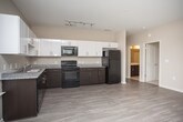 Located in College Park, GA, this single-floor residence offers a thoughtfully designed layout that balances comfort and functionality. The open-concept living and dining area is bathed in natural light from multiple large windows, complemented by light-toned wood-style flooring and a ceiling fan overhead. This space flows seamlessly into the kitchen, which is equipped with dark espresso lower cabinetry, crisp white upper cabinets, granite-style countertops, and black appliances including a range, microwave, refrigerator, and dishwasher — providing a well-stocked cooking environment. The bedrooms feature plush wall-to-wall carpeting, ceiling fans, and windows that allow natural light and outdoor views. An additional room with wood-style flooring offers flexible use as a bedroom, office, or den. The bathroom is finished with large-format cream tile flooring, dark espresso vanity cabinetry with a white countertop, a Hollywood-style vanity mirror, and a tiled shower-tub combination. Neutral warm-beige tones throughout the residence create a clean, cohesive aesthetic. The overall layout is practical and move-in ready, making this College Park residence a solid and comfortable living option.