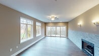 This single-floor residence offers a thoughtfully designed layout with a cohesive neutral palette and quality finishes throughout. The expansive living area is a standout space, featuring light hardwood flooring, a striking floor-to-ceiling stacked stone fireplace, a ceiling fan, recessed lighting, and large windows alongside wide French doors that flood the room with natural light and provide outdoor access. The kitchen is well-equipped with rich dark cabinetry, stainless steel appliances, a tile backsplash, and a generous granite island that serves as both a prep space and gathering point. The primary suite impresses with a tray ceiling accented by crown molding details and a ceiling fan, complemented by plush carpeting and ample natural light. Its en-suite bathroom is a luxurious retreat, showcasing marble-look tile flooring, dual vanities with marble countertops, a freestanding soaking tub, a glass-enclosed shower, and elegant gold-tone fixtures. Additional bedrooms feature soft carpeting and walk-in closets, while a secondary bathroom offers dark floor-to-ceiling tiled walls surrounding a tub-shower combination and a dual-sink vanity. Versatile bonus rooms with hardwood flooring and recessed lighting add flexibility to the overall floor plan.