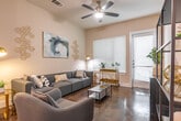 This single-floor residence combines contemporary design with comfortable living across a well-organized layout. The living room serves as the heart of the space, featuring polished concrete floors that run throughout, neutral walls that create a bright and airy atmosphere, and a ceiling fan with integrated lighting. Large windows and a glass-paneled door allow natural light to fill the room while offering views of a private outdoor area. Abstract wall art and decorative accents add a curated, modern aesthetic.

The kitchen is designed for both function and style, showcasing rich dark-stained cabinetry that extends to the ceiling for generous storage, light quartz countertops, a white tile backsplash, and a full suite of stainless steel appliances. Under-cabinet lighting highlights the workspace, while a pendant light adds a refined finishing touch. A double-door closet nearby provides additional storage.

The bedroom offers a calm retreat with plush carpeting, tall ceilings, and access to a dedicated closet and en-suite bathroom. The bathroom features dark wood cabinetry, a wide vanity with a large framed mirror, a well-lit vanity bar, and a tiled shower-tub combination. Geometric wall décor adds a contemporary touch throughout this thoughtfully designed residence.