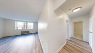 Located at 3111 Eglinton Ave E in Toronto, this well-appointed 2-bedroom, 1-bathroom unit offers a thoughtfully organized single-floor layout. Light wood laminate flooring flows consistently throughout the space, creating a clean and cohesive aesthetic. The kitchen is a standout feature, equipped with white shaker-style cabinetry, a white subway tile backsplash, stainless steel appliances including a range, dishwasher, and refrigerator, and a peninsula with a dark countertop that provides additional workspace and separates the kitchen from the living area. The open living room is bright and spacious, with crisp white walls and generous wall space. Both bedrooms are well-sized, featuring large windows that bring in natural light and offer views of the surrounding greenery. Each bedroom is fitted with a built-in double-door closet and a classic radiator unit for heating. The primary bedroom offers a comfortable footprint suitable for a full furniture arrangement. The bathroom features a full tub-and-shower combination with white subway tile surround and chrome fixtures, paired with a white vanity. A hallway connects all rooms efficiently, completing this practical and move-in ready layout.