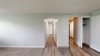 Located at 4389 Plantation Blvd in Liverpool, NY, this single-floor, 2-bedroom, 1-bathroom unit offers a functional and straightforward layout across a compact but well-organized footprint. Neutral light gray walls and white trim are consistent throughout, lending a clean and cohesive look to the space.

The living room features wall-to-wall carpet, providing a comfortable and quiet atmosphere. A central hallway connects the main living area to the rest of the unit and includes two closets, offering practical storage. The hallway and common areas feature wood-style plank flooring that adds warmth and is easy to maintain.

The kitchen is equipped with warm-toned wood cabinetry, laminate countertops, a stainless steel sink, and includes a dishwasher. The primary bedroom is a well-sized room with carpet flooring, a window unit air conditioner, baseboard heating, and an exterior-facing window. The second bedroom also features carpet flooring and a window that allows natural light.

The full bathroom includes a tub/shower combo with a white surround, wood-style flooring, and clean white fixtures. Overall, the unit presents a practical and move-in-ready living environment.