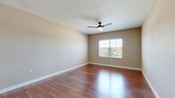 Located at 1715 Tamiami Trail in Bradenton, Florida, this single-story, 2-bedroom, 1-bathroom residence offers a thoughtfully designed layout with consistent finishes throughout. Rich hardwood flooring flows through the open-concept living room and kitchen area, creating a warm and cohesive aesthetic. The kitchen is well-appointed with rich wood cabinetry, granite countertops, stainless steel appliances including a refrigerator, range, and microwave, and a peninsula with pendant lighting that doubles as a casual dining or workspace. The spacious living room features a ceiling fan with light fixture and offers a clear sightline to the kitchen.

Both bedrooms are generously proportioned, each featuring hardwood flooring, ceiling fans, and windows fitted with blinds that allow for natural light and outdoor views. The primary bedroom includes a double-door closet for ample storage. Neutral, warm-toned walls throughout the home provide a clean, versatile backdrop.

The bathroom is designed with accessibility in mind, featuring grab bars, large-format tile flooring, a granite-topped wood vanity with a wide mirror, and a spacious layout. A connecting hallway ties the rooms together efficiently. The overall ambiance is clean, functional, and move-in ready.