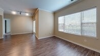 Located at 405 Rolling Brook Drive in Charlotte, NC, this single-story unit offers a well-organized layout that makes efficient use of its space. The open-concept living and kitchen area is anchored by warm hardwood-style flooring and crown molding, lending a polished look throughout. Large windows fitted with blinds allow generous natural light to fill the living room, creating a bright and welcoming atmosphere.

The kitchen is a functional highlight, featuring white cabinetry, a subway tile backsplash, stainless steel appliances including a range and built-in microwave, and a granite-topped peninsula with a sink — ideal for both meal prep and casual dining. Track lighting overhead ensures the kitchen is well-lit at all times.

The bedroom is a comfortable, carpeted retreat with a sizable window overlooking greenery outside, offering a tranquil view. A dedicated walk-in closet off the bedroom provides ample storage with wire shelving systems spanning multiple walls, maximizing organization. The neutral, warm-toned walls throughout the unit create a cohesive and inviting ambiance, making it easy to personalize the space to any style.