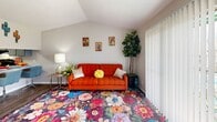 This 490 square foot apartment in Houston, TX, maximizes its compact layout with a thoughtful design. The single-floor plan encompasses one bedroom, one bathroom, and an open-concept living area. The living room stands out with its vibrant decor, featuring a striking orange sofa and a colorful floral area rug that adds warmth and character to the space.

The bedroom, measuring 130 square feet, boasts a large bed with a tufted headboard and bold orange bedding, complemented by blue accents and decorative crosses. A sliding glass door in the living area allows natural light to flood the space and provides a view of the outdoor area, possibly a communal space or pool.

The kitchen, while compact, is efficiently designed with modern appliances, including a stainless steel refrigerator and dishwasher. Light gray cabinetry and granite countertops offer a sleek look. The bathroom, though small, features a large mirror, single vanity, and necessary amenities.

Throughout the apartment, the decor scheme balances neutrals with pops of color, creating a lively and modern atmosphere. Potted plants and artistic wall hangings add personality to the space. The apartment's layout, while cozy, appears well-planned to maximize functionality and style in its 490 square feet.