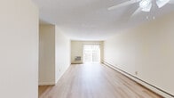 Located at 700 Metacom Ave in Warren, Rhode Island, this two-bedroom, one-bathroom residence offers a comfortable and functional single-floor layout. The living room is bright and open, featuring light hardwood-style flooring, a textured ceiling, baseboard heating, and a large sliding glass door dressed with vertical blinds that fills the space with natural light and provides outdoor access. The kitchen is efficiently designed with cream cabinetry, ample counter space, a gas range, and tile flooring, with room for additional appliances. Both bedrooms are carpeted and include ceiling fans with integrated lighting and baseboard heating. The generously sized primary bedroom features dual sliding closets offering substantial storage, while the second bedroom also benefits from natural light and a ceiling fan. A hallway connects the main living areas, with two closets providing additional storage throughout. The full bathroom includes a tub-shower combination. A dedicated laundry area adds everyday convenience. The unit's neutral color palette of warm whites and creams lends a clean, cohesive aesthetic throughout, making it a practical and move-in ready residence.