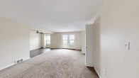 Located at 321 Evans Street in Williamsville, NY, this single-floor, 2-bedroom, 1-bathroom home offers a thoughtfully organized layout with a clean, neutral aesthetic throughout. The living room is a welcoming space featuring plush carpeting, a ceiling fan, and French doors that open to an outdoor balcony, filling the room with natural light. An adjacent area with hardwood-style flooring extends the living space and offers additional versatility. The kitchen is equipped with warm wood cabinetry, granite countertops, stainless steel appliances including a refrigerator and dishwasher, and durable hardwood-style flooring — a functional and attractive space for cooking and entertaining. The spacious primary bedroom features soft carpeting and two generous closets with bifold doors, providing ample storage. The second bedroom offers hardwood-style flooring, a bright window with neighborhood views, and a clean, versatile layout. A built-in shelving unit in one room adds practical storage and display options. The full bathroom is finished with warm beige tile, a tub-shower combination, and a wood-toned vanity. A connecting hallway ties the rooms together efficiently, completing this comfortable and well-maintained home.