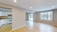 Located at 759 Burr Oak Ln in University Park, IL, this single-floor home offers a clean, modern aesthetic with a thoughtfully designed layout. The open living and dining areas are bathed in natural light, thanks to large sliding glass doors and wide windows that frame outdoor views. Light wood-tone flooring runs seamlessly throughout, complementing the neutral gray wall tones that lend the space a fresh, contemporary feel. Recessed lighting and a ceiling fan enhance comfort across the main living zones.

The kitchen is well-appointed with white shaker cabinetry, granite-style countertops, a stainless steel sink with a gold-tone faucet, and white appliances including a gas range, refrigerator, and dishwasher — providing both style and functionality. A dedicated laundry area with hookups adds everyday convenience.

The bedrooms are comfortably sized, each featuring the same warm wood flooring and windows that bring in natural light. The bathrooms are finished in a clean, neutral palette — one with a granite-topped vanity and modern fixtures, and another with a full tub-shower combination and tiled surround. A six-panel entry door and crisp white trim complete the polished, move-in-ready presentation of this well-maintained home.