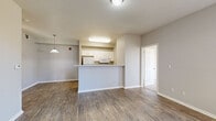 Located at 3775 W 25th St in Greeley, Colorado, this single-floor residence offers a functional and thoughtfully designed layout throughout. The open-concept living and dining area greets you upon entry through a bold blue front door, featuring durable wood-style flooring and neutral gray walls that create a clean, modern aesthetic. A pendant light adds a decorative touch to the living space. The kitchen is organized around a peninsula counter that separates it from the main living area, providing both prep space and a natural gathering point. White cabinetry, white appliances including a refrigerator, electric range, built-in microwave, and dishwasher, along with a double basin sink, equip the kitchen fully. The bedrooms offer plush carpeting and ample natural light through large windows with exterior views of the surrounding neighborhood. Closet access is conveniently located within the bedrooms. The bathroom is finished with white tile surrounding a full soaking tub and shower combination, accented by a warm tile border, a white vanity with a large mirror, and wood-style flooring. Throughout the residence, a consistent neutral palette, clean lines, and practical finishes contribute to a comfortable and move-in-ready living environment.