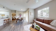 This single-floor residence offers a thoughtfully designed open-concept layout that seamlessly connects the living, dining, and kitchen areas. The living room features wood-look flooring, a ceiling fan, and large windows fitted with vertical blinds that allow generous natural light to fill the space. The dining area sits adjacent to the living room, highlighted by a sliding glass door that further brightens the space with outdoor views.

The kitchen is outfitted with crisp white cabinetry, granite countertops, a stainless steel undermount sink, and wood-look flooring, providing a clean and functional workspace.

Both bedrooms are carpeted and comfortably sized, each featuring ceiling fans, windows with natural light, and neutral wall tones. The primary bedroom includes access to a walk-in closet and a private en-suite bathroom. The bathrooms are finished with granite-top vanities, wood-look flooring, and shower-tub combinations, offering a consistent and polished aesthetic throughout.

The overall ambiance of the space is warm and neutral, with soft gray tones on the walls, coordinated finishes, and an inviting atmosphere that flows naturally from room to room. The layout is practical and cohesive, making efficient use of the single-floor footprint.