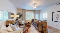 This thoughtfully designed 2-bedroom, 2-bathroom single-floor residence offers a functional and comfortable layout across a well-utilized footprint. The living room serves as the heart of the home, featuring hardwood-style flooring, a textured ceiling, a ceiling fan, and large windows dressed with floor-length curtains that invite generous natural light. The space flows seamlessly, offering room for both relaxed seating and a dedicated workspace area.

The kitchen is equipped with rich warm-toned wood cabinetry extending to the upper walls for ample storage, granite countertops, and stainless steel appliances including a range and built-in microwave. Hardwood-style flooring continues throughout this space.

The primary bedroom is generously sized, featuring plush carpeting, dual windows with outdoor views, and ample natural light. The second bedroom offers a similarly comfortable feel with carpeted flooring, a window, and closet access. Both bathrooms are finished with granite-topped vanities and warm wood cabinetry, with one featuring a shower-tub combination.

A dedicated laundry room houses a full-size washer and dryer with overhead shelving. A spacious walk-in closet with built-in shelving and hanging rods provides excellent storage. The hallway connects all rooms efficiently, completing this well-organized and inviting residence.