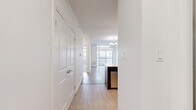 Located at 15 Maple Ave in Barrie, Ontario, this well-appointed one-bedroom, one-bathroom unit offers a thoughtfully designed single-floor layout. The open-concept living and kitchen area forms the heart of the unit, featuring light hardwood flooring, a modern chandelier, and floor-to-ceiling sliding glass doors that lead to a private balcony, flooding the space with natural light and offering views of the surrounding neighbourhood.

The kitchen is a standout, showcasing rich dark cabinetry, a mosaic tile backsplash, stainless steel appliances, and a large peninsula with a white quartz countertop and breakfast bar seating — ideal for both cooking and casual dining. Pendant lighting above the peninsula adds a polished, contemporary touch.

The bedroom is a comfortable retreat with plush carpeting, crisp white walls, and a window that brings in ample natural light. The bathroom is finished with clean white tile, a soaker tub, a glass-enclosed shower, and chrome fixtures, creating a bright, spa-like atmosphere.

A dedicated in-unit laundry area with a stacked washer and dryer adds everyday convenience, while a closet provides additional storage. The unit's clean, neutral palette and modern finishes make it a functional and stylish living space.
