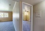 Located at 115 Louie Ave in Lodi, CA, this one-bedroom, one-bathroom unit offers a well-organized and functional layout across a single floor. The space is designed for comfortable everyday living, with each room thoughtfully arranged to maximize utility.

The bedroom is generously sized and features plush carpeting, crown molding, and a ceiling fan with a light fixture for year-round comfort. A built-in sliding-door closet provides ample storage, while a sliding glass door opens to an outdoor area, allowing natural light to fill the room and offering views of the surrounding greenery.

The kitchen is laid out in a galley style, featuring warm wood cabinetry both above and below the countertops, white appliances including a coil-top range and a full-size refrigerator, and light hardwood-style flooring that adds a clean, modern touch.

The bathroom is practical and accessible, equipped with hardwood-style flooring, a wood-panel storage cabinet, a walk-in shower with safety grab bars, and a vanity with countertop space. The hallway connects the rooms efficiently, finished with textured walls and carpeting that continues the cohesive aesthetic throughout the home.

Overall, the unit presents a neutral, move-in-ready ambiance with consistent finishes and a straightforward, comfortable design.