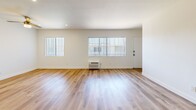 Located at 15343 Vanowen St in Van Nuys, Los Angeles, this single-floor, 2-bedroom, 2-bathroom unit offers a clean and functional layout with a bright, neutral palette throughout. Light wood-style flooring runs continuously across every room, creating a cohesive and easy-to-maintain finish.

The open living room receives generous natural light through large windows fitted with vertical blinds, and includes a wall-mounted air conditioning unit for climate control. It flows directly into the kitchen area, which features white shaker-style cabinetry, marble-look countertops, a stainless steel sink, and a white gas range — all accented by a structural column that subtly defines the two spaces.

Both bedrooms are comfortably sized with crisp white walls. The primary bedroom includes a dedicated walk-in closet with built-in shelving and hanging rods, offering ample storage. The second bedroom features a sliding-door closet. Each room is served by its own window and wall-mounted air conditioning unit.

The two bathrooms each present distinct designs: one offers a shower stall with a single vanity, while the second features a full soaking tub with warm earth-tone tile surround, a vanity, and a small window for natural light. A hallway connects the private areas of the unit seamlessly.
