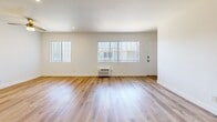 Located at 15343 Vanowen St in Van Nuys, Los Angeles, this single-floor, 2-bedroom, 2-bathroom unit offers a clean and functional layout with a bright, neutral palette throughout. Light wood-style flooring runs continuously across every room, creating a cohesive and easy-to-maintain finish.

The open living room receives generous natural light through large windows fitted with vertical blinds, and includes a wall-mounted air conditioning unit for climate control. It flows directly into the kitchen area, which features white shaker-style cabinetry, marble-look countertops, a stainless steel sink, and a white gas range — all accented by a structural column that subtly defines the two spaces.

Both bedrooms are comfortably sized with crisp white walls. The primary bedroom includes a dedicated walk-in closet with built-in shelving and hanging rods, offering ample storage. The second bedroom features a sliding-door closet. Each room is served by its own window and wall-mounted air conditioning unit.

The two bathrooms each present distinct designs: one offers a shower stall with a single vanity, while the second features a full soaking tub with warm earth-tone tile surround, a vanity, and a small window for natural light. A hallway connects the private areas of the unit seamlessly.