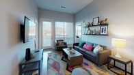 Located on West Colfax Avenue in Denver, Colorado, this single-floor unit features a contemporary open-concept layout with clean lines and modern finishes throughout. Light wood-style flooring flows seamlessly across the living, dining, and kitchen areas, contributing to a cohesive and airy atmosphere.

The kitchen is well-appointed with white upper cabinetry, light lower cabinets, and a classic white subway tile backsplash. Stainless steel appliances — including a refrigerator, range, microwave, and dishwasher — provide a polished, functional workspace. A dining table positioned adjacent to the kitchen offers a practical and connected eating area.

The living room receives generous natural light through large windows and French doors that open to an outdoor area, creating a bright and welcoming environment. The space connects directly to the bedroom corridor, maintaining an efficient and open floor plan.

Two bedrooms are included, each featuring large windows that allow ample natural light and views of the surrounding streetscape. The bedrooms offer enough space for a bed and desk setup.

Two bathrooms feature walk-in glass-enclosed showers with white tile surrounds, wood-style flooring, and clean, neutral finishes. The overall design of the unit prioritizes a modern, functional aesthetic suitable for urban living.
