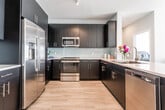 Located in Elmwood Park, NJ, this contemporary single-floor residence offers a well-designed layout that balances modern style with everyday comfort. Light-toned hardwood flooring flows throughout the space, creating a warm and cohesive aesthetic across every room.

The kitchen is a standout feature, outfitted with dark navy cabinetry, white quartz countertops, a subway tile backsplash, and a full suite of stainless steel appliances including a French door refrigerator, electric range, microwave, and dishwasher. The open-concept dining and living area adjacent to the kitchen is bright and airy, with recessed lighting and large windows that invite natural light.

Multiple bedrooms provide versatile living options. The primary bedroom is highlighted by a soft blue accent wall, light wood floors, and a serene ambiance. A second bedroom features neutral gray tones, a walk-in closet, and natural light from nearby windows, while a third bedroom offers a quiet, minimalist feel with a large window.

Two bathrooms serve the space. The primary bathroom includes a dual-sink vanity with dark cabinetry, a large mirror, and a walk-in shower. The secondary bathroom features a single-sink vanity with light wood cabinetry and a full tub-shower combination with elegant tile accents. Together, these spaces deliver a clean, modern living experience.