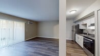 This single-floor studio in Inkster, Michigan, offers a thoughtfully designed layout that maximizes functionality within a compact footprint. The open living area is finished with durable wood-style plank flooring throughout, lending a clean, contemporary aesthetic. Neutral-toned walls create a versatile backdrop, while a large sliding glass door fitted with vertical blinds allows natural light to fill the space and provides outdoor access. A wall-mounted air conditioning unit ensures climate control year-round.

The kitchen is efficiently arranged along one wall and is separated from the main living area by a structural column that subtly defines each zone. It features white shaker-style cabinetry with brushed nickel hardware, dark countertops, a double-basin stainless steel sink, a stainless steel refrigerator, and a stainless steel electric range with an overhead exhaust hood. Ample upper and lower cabinet storage adds practical appeal.

The bathroom is finished in a clean, all-white palette with wood-style flooring, a full tub-shower combination, and standard fixtures. The overall design of this studio prioritizes clean lines, updated finishes, and efficient use of space, making it a practical and modern option.