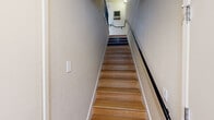 Located at 1190 Olsen Dr in San Jose, CA, this multi-story home spans three floors, offering a well-organized layout across a comfortable footprint. The entry level serves as a compact transitional space leading to the main living areas above.

The first main floor hosts the combined kitchen and living room alongside a dining area. The kitchen features white shaker cabinetry, stainless steel appliances including a French door refrigerator and range, dark countertops, and recessed lighting. Light hardwood-style flooring runs throughout, adding warmth and continuity. A decorative staircase with patterned tile risers and a sleek black metal railing serves as a visual focal point. The dining area benefits from multiple wood-framed windows that invite natural light and views of the surrounding neighborhood.

The living room offers large windows and a bright, open ambiance. The upper floor houses two bedrooms and two bathrooms. The generously sized primary bedroom includes a closet with built-in shelving and a window for natural light. The bathrooms feature tub-shower combinations, tile flooring, and vanities with granite-style countertops. Consistent hardwood-style flooring and neutral wall tones create a cohesive, welcoming atmosphere throughout the home.