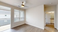 Located at 2300 N Broad St in Fuquay-Varina, NC, this one-bedroom, one-bathroom unit offers a thoughtfully designed single-floor layout that maximizes its compact footprint. The interior features a consistent palette of neutral tones and light-toned wood-style flooring throughout the main living areas, contributing to a clean, cohesive aesthetic.

The kitchen serves as a functional centerpiece, showcasing white shaker-style cabinetry, granite countertops, a subway tile backsplash, and a full suite of stainless steel appliances including a refrigerator, range, microwave, and dishwasher. A kitchen island with built-in shelving and a granite surface provides additional prep and seating space. A stacked washer and dryer unit is conveniently housed just off the kitchen.

The living room receives natural light through a window fitted with blinds and features a ceiling fan with a light fixture overhead. The bedroom, finished with plush carpeting, is a comfortable size and includes access to a dedicated closet with built-in shelving. The bathroom offers a glass-enclosed walk-in shower, wood-style flooring, and direct access to a walk-in closet with wire shelving. The overall ambiance is bright, modern, and move-in ready.