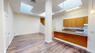 Located at 73 Washington St in New London, CT, this two-bedroom, two-bathroom unit offers a thoughtfully designed single-floor layout. The open-concept kitchen and living area serves as the heart of the home, highlighted by two large skylights that flood the space with natural light. Durable hardwood-style flooring runs throughout the main living areas, complementing the clean, neutral walls. A structural column adds an architectural touch to the open floor plan, while a pendant light fixture anchors the kitchen zone. The kitchen is well-equipped with warm-toned wood cabinetry, dark granite-style countertops, a double sink, and white appliances including a range and dishwasher. A generous island provides additional prep and dining space. Both bedrooms are carpeted for comfort; the primary bedroom offers a spacious layout, while the second bedroom includes a built-in closet with a hanging rod. A bonus room with its own skylight and hardwood-style flooring provides flexible space for a home office or den. The two bathrooms include a full tub-shower combo. A staircase and hallway complete the layout, adding connectivity throughout the unit.