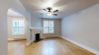 Located at 608 S Stevens St in Spokane, WA, this one-bedroom, one-bathroom unit offers a well-organized single-floor layout filled with vintage charm and classic architectural details. Warm hardwood floors run throughout the main living areas, complementing the soft neutral and blue-gray wall tones that give the space a calm, cohesive character. The living room is a standout, featuring a decorative fireplace with a classic mantle surround, a ceiling fan, and a window that brings in natural light. Elegant arched doorways connect the living room to the dining room and kitchen, adding architectural interest and an open sense of flow. The dining room includes a chandelier and its own window, while the kitchen is equipped with white cabinetry, a range, and a refrigerator tucked within an arched alcove. The spacious primary bedroom features hardwood floors, dual wall sconces, and multiple windows. An additional room with blue-gray walls offers flexibility for various uses. The bathroom is finished with white tile wainscoting, a tub-shower combination, a pedestal sink, and a windowed medicine cabinet. In-unit laundry adds everyday convenience to this well-appointed, character-rich Spokane residence.