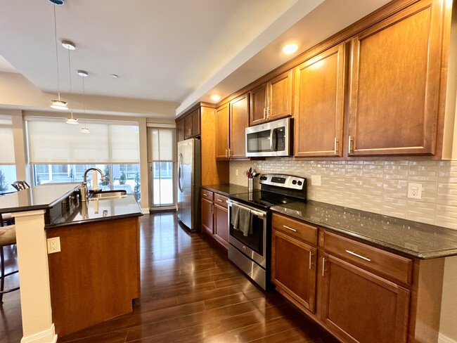 Kitchen with stainless steel appliances - Peregrine Plaza