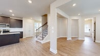 Located at 2311 Spring Rush Dr in Buford, GA, this expansive two-story home offers six bedrooms and four bathrooms across a generously sized layout. The main floor commands the majority of the living space and features an open-concept design that seamlessly connects the living room, dining area, and kitchen. The kitchen is appointed with dark espresso cabinetry, stainless steel appliances, a classic subway tile backsplash, and a large granite-topped island ideal for both meal prep and casual dining. Light hardwood flooring flows throughout the main level, complementing the neutral warm-beige walls and recessed lighting. Large windows allow abundant natural light into the living and dining areas, while a ceiling fan adds comfort to the living room. A stylish staircase with iron balusters leads to the upper level, which houses additional bedrooms. The bedrooms feature plush carpeting and natural light from well-placed windows. Closets include a walk-in with wire shelving systems, offering ample storage. The bathrooms are clean and bright with natural window light. A dedicated laundry area with hookups, a two-car garage with automatic door openers, and a hallway connecting key areas round out this well-planned, functional home.