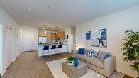 This thoughtfully designed 2-bedroom, 2-bathroom residence is laid out entirely on a single level, offering a functional and cohesive floor plan. The open-concept living and kitchen area serves as the heart of the home, featuring warm wood-toned cabinetry, dark quartz countertops, white subway tile backsplash, and stainless steel appliances. A peninsula with bar seating provides an ideal space for casual dining, while pendant lighting adds a modern touch overhead. The living room flows naturally from the kitchen, with durable wood-look flooring underfoot and a bright, neutral palette throughout. A large window at the far end of the living area brings in abundant natural light.

Both bedrooms are carpeted and well-proportioned, each featuring large windows with generous natural light. The primary bedroom includes an en-suite bathroom equipped with a dual-sink vanity, light wood cabinetry, and dark quartz countertops, along with a spacious walk-in closet featuring wire shelving. The second bathroom mirrors the same clean, contemporary finishes. A hallway connects the private sleeping quarters to the main living spaces, and two closets provide ample built-in storage. The overall ambiance is modern, clean, and move-in ready.