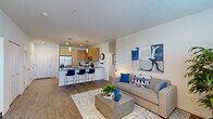 This thoughtfully designed 2-bedroom, 2-bathroom residence is laid out entirely on a single level, offering a functional and cohesive floor plan. The open-concept living and kitchen area serves as the heart of the home, featuring warm wood-toned cabinetry, dark quartz countertops, white subway tile backsplash, and stainless steel appliances. A peninsula with bar seating provides an ideal space for casual dining, while pendant lighting adds a modern touch overhead. The living room flows naturally from the kitchen, with durable wood-look flooring underfoot and a bright, neutral palette throughout. A large window at the far end of the living area brings in abundant natural light.

Both bedrooms are carpeted and well-proportioned, each featuring large windows with generous natural light. The primary bedroom includes an en-suite bathroom equipped with a dual-sink vanity, light wood cabinetry, and dark quartz countertops, along with a spacious walk-in closet featuring wire shelving. The second bathroom mirrors the same clean, contemporary finishes. A hallway connects the private sleeping quarters to the main living spaces, and two closets provide ample built-in storage. The overall ambiance is modern, clean, and move-in ready.