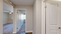Located at 4348 N Chestnut St in Colorado Springs, CO, this single-floor, one-bedroom, one-bathroom unit offers a practical and efficiently designed layout. The kitchen is outfitted with rich dark-wood cabinetry, white countertops, wood-look flooring, and black appliances including a refrigerator, range, and dishwasher, providing ample storage and counter space. The layout transitions smoothly through connecting hallways, lending a sense of flow throughout the unit. The bedroom is a comfortable, well-proportioned room featuring plush carpeting, a ceiling fan with light fixture, a natural light-admitting window with vertical blinds, and a baseboard heating unit. A dedicated closet provides convenient storage directly off the hallway. The bathroom is tastefully finished with a modern wood-toned vanity, white countertop, large mirror, wood-look tile flooring, and a shower/tub combination. Neutral wall tones and textured ceilings carry throughout the unit, creating a cohesive and understated aesthetic. Hardwood-look flooring in the hallways and kitchen contrasts neatly with the carpeted bedroom, adding visual variety. This unit offers a compact yet complete living environment suited for comfortable everyday living.