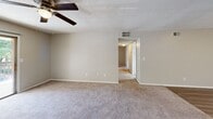 Located at 1400 Cherokee Rd in Florence, South Carolina, this single-story, three-bedroom, two-bathroom home offers a practical and comfortable layout. The galley-style kitchen is well-appointed with white cabinetry, dark granite-style countertops, a double sink, and white appliances including an electric range and refrigerator. Light wood-look flooring runs through the kitchen and dining area, which flows openly into the living space. The living room is generously sized, featuring soft carpeting, a ceiling fan with light fixture, and a hallway leading to the bedrooms. Each bedroom is carpeted and finished with neutral tones, offering a calm atmosphere. The primary bedroom includes direct access to a full bathroom and a dedicated closet. Secondary bedrooms are equipped with louvered bi-fold closet doors and windows that bring in natural light with views of surrounding greenery. The bathrooms are clean and functional — one features a wide vanity with white cabinetry, a large mirror, brushed nickel fixtures, and wood-look flooring, while the other includes a full tub-shower combination. A hallway connects the main living areas to the bedrooms, completing this efficiently designed single-level home.