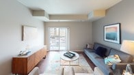 This single-floor residence offers a thoughtfully designed layout that balances modern aesthetics with everyday functionality. The kitchen serves as a standout feature, showcasing rich dark wood cabinetry, granite countertops, a classic white subway tile backsplash, and a full suite of stainless steel appliances including a refrigerator, dishwasher, microwave, and electric range. A central island with a matching granite surface provides additional prep space and casual dining potential, while warm hardwood flooring ties the space together. The open living area is bright and inviting, featuring sliding glass doors that lead to a private balcony and allow natural light to fill the room. Two well-sized bedrooms offer plush carpeting and windows with outdoor views, creating a calm and restful atmosphere. Each bedroom benefits from dedicated closet space. The residence includes two bathrooms, both finished with granite-topped dark wood vanities and tile flooring. The primary bathroom features a dual-sink vanity with dual mirrors and ample storage, while the second bathroom offers a single vanity with a shower and tub combination. Throughout the space, a neutral color palette and consistent use of quality materials contribute to a cohesive, modern living environment.