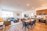 Located at 3222 Mission Village Drive in San Diego, CA, this well-designed 2-bedroom, 2-bathroom single-floor residence offers a thoughtfully planned open-concept layout. The combined living, dining, and kitchen area forms the heart of the home, bathed in natural light from large corner windows that frame views of the surrounding neighborhood. Light hardwood-style flooring flows throughout the main living spaces, complementing the clean white walls and recessed lighting overhead.

The modern kitchen is outfitted with sleek wood-grain cabinetry extending to the ceiling, white quartz countertops, a subway tile backsplash, and stainless steel appliances including a refrigerator, range, and built-in microwave. A dedicated dining area sits adjacent, ideal for everyday meals or entertaining.

The primary bedroom is generously sized, featuring multiple windows on two walls that invite plenty of natural light and offer outdoor views. The second bedroom is equally bright, with a large window and soft carpeting underfoot. Both bathrooms mirror the home's contemporary aesthetic, showcasing wood-toned vanities with white countertops and tub-shower combinations with light hardwood-style flooring.

Additional spaces include a hallway, two closets, a laundry area, a utility room, and a private patio — rounding out this functional and stylish San Diego residence.