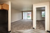 Located at 2806 Fleur Dr in Des Moines, Iowa, this one-bedroom, one-bathroom unit offers a functional and straightforward layout across a single floor. The living area is carpeted and features a sliding glass door with vertical blinds, allowing natural light to filter in while providing outdoor views of the surrounding greenery. A wall-mounted air conditioning unit serves the space efficiently.

The galley-style kitchen is equipped with warm oak cabinetry — both upper and lower — dark granite-style countertops, a stainless steel sink, and black appliances including a full-size refrigerator and range. Light-toned laminate flooring runs throughout the kitchen, complementing the neutral color palette.

The bedroom is a comfortable size, featuring plush carpet, a window with natural light, and a baseboard heating unit. An adjacent dedicated closet with built-in shelving provides practical storage. The textured ceilings are consistent throughout the unit, adding a classic residential feel.

The bathroom includes a single-sink vanity with white cabinetry, a mirrored medicine cabinet, and a tiled tub-shower combination. Neutral tones throughout the bathroom contribute to a clean, utilitarian aesthetic. Overall, this unit offers a practical and well-organized living space suitable for individuals or couples.