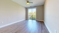 Located at 1000 Central Ave in Charlotte's vibrant Plaza Midwood neighborhood, this one-bedroom, one-bathroom unit offers a well-designed layout across a single floor. Light-toned wood-style flooring runs throughout, creating a cohesive and clean aesthetic from room to room.

The kitchen is a standout feature, showcasing high-gloss gray cabinetry, a white subway tile backsplash, granite countertops, and a full suite of stainless steel appliances including a range, microwave, dishwasher, and refrigerator. A peninsula provides additional counter space and a natural transition into the adjoining living area, which benefits from a ceiling fan and a sliding glass door that opens to a private balcony overlooking greenery.

The bedroom is a well-proportioned retreat featuring a ceiling fan, multiple windows that invite natural light, and a dedicated closet for storage. Neutral warm-gray walls throughout the unit provide a versatile backdrop adaptable to a variety of décor styles.

The bathroom is finished with classic white square tile surrounding a soaking tub and shower combination, complemented by brushed nickel fixtures and wood-style flooring that ties seamlessly to the rest of the unit. The overall design balances modern finishes with functional, comfortable living.