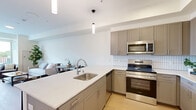 Located at 329 E College Ave in Appleton, WI, this thoughtfully designed one-bedroom, one-bathroom unit offers a modern aesthetic across a single floor. The open-concept layout seamlessly connects the living room, dining area, and kitchen, creating a bright and functional central space. Light wood-tone flooring runs throughout, complementing the clean white walls and contemporary finishes.

The kitchen is a standout feature, equipped with stainless steel appliances including a range, microwave, and refrigerator. Gray shaker-style cabinetry with brushed hardware provides ample storage, while a white subway tile backsplash adds a crisp, modern touch. A peninsula with a sink and seating overhang serves as both a prep area and casual dining space, accented by pendant lighting overhead.

The living room benefits from large sliding glass doors that open to a private balcony, flooding the space with natural light and offering outdoor views of the surrounding neighborhood. The bedroom is a comfortable retreat with its own window overlooking the outdoors. The full bathroom features a tub-shower combination. A dedicated laundry closet houses a stacked washer and dryer unit, adding everyday convenience. Additional spaces include an entrance, hallway, closet, and utility room.