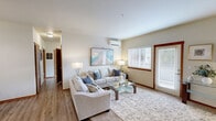 Located in Edgewood, Washington, this single-floor, 3-bedroom, 2-bathroom unit offers a well-organized and functional layout. The open kitchen is a standout feature, showcasing modern wood-tone cabinetry, white countertops with a double-basin sink, and stainless steel appliances including a refrigerator, microwave, and range. Wood-look vinyl flooring grounds the kitchen, adding warmth and easy maintenance.

The living room is bright and spacious, with plush carpeting, neutral walls, and a sliding glass door fitted with vertical blinds that invite natural light and provide access to an outdoor area. A wall-mounted mini-split air conditioning unit ensures year-round comfort.

Each of the three bedrooms features soft carpeting and sliding-door closets with built-in hanging rods for ample storage. The bedrooms are well-lit, with windows dressed in blinds, and include baseboard heating in select rooms. The primary bedroom offers a generously sized closet.

Both bathrooms are clean and practical, featuring full tub-shower combinations with white surrounds, chrome fixtures, and wood-look vinyl flooring. The overall aesthetic throughout the unit is cohesive and neutral, creating a move-in-ready environment suited for comfortable everyday living.