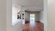 This well-designed apartment maximizes its 860 square feet of living space across a single floor. The layout includes two bedrooms, two full bathrooms, and an open-concept living, dining, and kitchen area. The primary bedroom is generously sized at 190 square feet, providing ample space for relaxation and storage.

The living spaces showcase a blend of flooring materials, with warm hardwood in the main living areas and plush carpeting in the bedrooms. Large windows in the living room and bedrooms allow for natural light and outdoor views, while sliding glass doors in one room lead to a private balcony.

The kitchen is equipped with modern stainless steel appliances, including a refrigerator, stove, and built-in microwave. Light wood cabinetry and dark countertops create a pleasant contrast, while tile flooring adds durability to the space.

Both bathrooms feature standard amenities, including a bathtub-shower combination, single vanity, and toilet. The neutral color palette throughout the apartment provides a blank canvas for personal decoration.

Additional features include ceiling fans in the bedrooms for improved air circulation and a closet in the hallway for extra storage. The textured ceilings and clean white walls contribute to the apartment's contemporary feel, making it an inviting and functional living space.