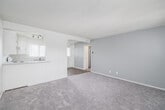 Located at 1321 W Rosecrans Ave in Gardena, California, this single-floor unit offers a clean, neutral palette throughout, creating a bright and functional living environment. The open living area features plush carpeting and a textured ceiling, with a pass-through window connecting directly to the kitchen, promoting an open and communicative flow between spaces. Natural light filters in through vertical-blind-covered windows, and a ceiling fan provides added comfort. The kitchen is well-appointed with white cabinetry, a patterned tile backsplash, stone-look countertops, a double stainless steel sink, and a white electric range with overhead ventilation. Light wood-look flooring ties the kitchen together with a clean, modern feel. The bedrooms are carpeted and generously sized, each benefiting from large windows dressed with vertical blinds that allow ample natural light. One bedroom includes a ceiling fan for enhanced airflow. The front entry area features a solid door flanked by two windows, offering a welcoming and well-lit entrance. The bathroom is thoughtfully finished with a vanity featuring stone-look countertops, white cabinetry, a mirrored medicine cabinet, a combined tub and shower, and wood-look flooring, maintaining the cohesive aesthetic found throughout the unit.