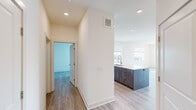 This thoughtfully designed two-bedroom, two-bathroom residence at 2800 Brighton Blvd in Denver's vibrant Brighton Boulevard corridor offers a seamless blend of modern aesthetics and functional living. Light-toned hardwood-style flooring flows throughout the single-level layout, complemented by recessed lighting and crisp white walls that create a bright, contemporary atmosphere.

The open-concept kitchen and living area serves as the heart of the home, anchored by a large center island with a white quartz countertop, dark wood cabinetry, a tile backsplash, and stainless steel appliances. Generous windows flood the living space with natural light and frame urban views of the Denver skyline.

Both bedrooms are well-proportioned, featuring ceiling fans, large windows, and sliding glass doors that open to a private balcony with city views. Each bedroom benefits from dedicated closet space, with the primary suite offering a walk-in closet equipped with adjustable shelving and hanging rods.

The primary bathroom is a standout feature, showcasing large-format marble-look tile flooring, an extended floating vanity with a white countertop, a framed mirror, and a separate walk-in shower. A hallway connects the bedrooms and bathrooms, ensuring a practical and private layout throughout this well-appointed Denver residence.