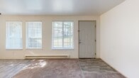Located at 2128 62nd Ave E in Fife, Washington, this one-bedroom, one-bathroom residence offers a practical and well-organized single-floor layout. The living room is generously sized, featuring plush carpeting, large windows with blinds that invite natural light, and a baseboard heating system. Two closet doors off the living area provide ample storage. The kitchen is laid out in a galley style with light wood cabinetry, white appliances including a range and refrigerator, a stainless steel sink, and durable wood-look flooring that continues into the adjacent dining area. The dining space benefits from multiple windows and a ceiling fan with light fixture, creating a bright and airy atmosphere. The bedroom is a comfortable size, outfitted with carpet flooring, a window overlooking the exterior, baseboard heating, and a full-width sliding closet. The bathroom includes a single-sink vanity, toilet, and a tub/shower combo with a window above for ventilation. Wood-look flooring ties the wet areas together cohesively. A dedicated laundry area and hallway with additional closet space round out the functional floor plan, making this a well-appointed and efficient home.