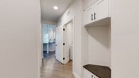 Located at 1500 Bell Road in Nashville, TN, this single-story, 2-bedroom, 2-bathroom home offers a thoughtfully designed layout with modern finishes throughout. The kitchen is equipped with white shaker-style cabinetry, dark granite countertops, a subway tile backsplash, and stainless steel GE appliances, including a side-by-side refrigerator and electric range. The hallway features a built-in mudroom area with white cabinetry and a dark countertop, providing convenient storage. A dedicated laundry room houses a full-size GE washer and dryer. The bathrooms include large-format tile flooring, white vanities with dark granite countertops, and matte black hardware accents. The spacious primary bedroom offers plush carpeting, a ceiling fan, and access to a generous walk-in closet with wire shelving. The secondary bedroom also features carpeted flooring, a ceiling fan, and natural light from a sizable window. Wood-look flooring runs through the main living areas, complementing the clean, neutral color palette. Recessed lighting and matte black door hardware create a cohesive, contemporary aesthetic throughout this well-appointed Nashville home.