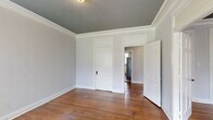 This single-floor, 3-bedroom, 1-bathroom home in Memphis, TN (38104) offers a classic layout with timeless architectural details throughout. Rich hardwood floors run through the bedrooms and hallway, complemented by crisp white crown molding and panel-style doors that lend a traditional character to the space. Each bedroom features its own closet and is accented by a distinctive dark-painted ceiling, creating a stylish contrast against the light gray walls. The primary bedroom is generously sized and benefits from multiple windows that invite natural light and outdoor views, with a ceiling fan adding comfort. The kitchen is well-appointed with white cabinetry, granite-style countertops, stainless steel gas range and refrigerator, a dishwasher, and light tile flooring. A door in the kitchen provides convenient exterior access. The bathroom is finished with classic white subway tile surrounding the tub, a black-and-white mosaic tile floor, and a vanity with mirror. A connecting hallway ties all rooms together, creating a cohesive and functional flow throughout this charming Memphis home.
