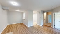 Located at 2800 New Brunswick Ave in Piscataway, NJ, this single-floor, three-bedroom, one-bathroom residence offers a well-organized layout across a comfortable footprint. The open living room features warm wood-style flooring and a sliding glass door fitted with vertical blinds, filling the space with natural light and providing outdoor access. Adjacent to the living area, the kitchen is appointed with crisp white shaker cabinetry, light tile flooring, and a full suite of stainless steel appliances including a gas range, over-the-range microwave, refrigerator, and dishwasher. The three bedrooms are finished with plush carpeting and receive natural light through windows overlooking greenery. The spacious primary bedroom includes double doors for added privacy. The full bathroom features tile flooring, a vanity, and a tub-shower combination with tile surround. A dedicated laundry room provides added convenience, housing a washer and dryer alongside a water heater and built-in wire shelving for storage. A hallway and closet complete the layout. Neutral gray walls, clean white trim, and consistent finishes throughout lend the space a cohesive, move-in-ready aesthetic.