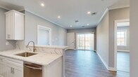 Located at 2421 Bristol Road in Warrington, PA, this thoughtfully designed 2-bedroom, 2-bathroom unit offers a clean, contemporary aesthetic throughout its well-appointed single floor. The open-concept kitchen anchors the living area, showcasing white shaker cabinetry with crown molding, striking veined quartz countertops, a peninsula with undermount sink, and a full suite of stainless steel appliances including a gas range, built-in microwave, refrigerator, and dishwasher. Recessed lighting and crown molding add a refined touch, while wood-look plank flooring flows seamlessly through the main living areas and bedrooms. Sliding glass doors lead from the living area to an outdoor space, filling the room with natural light. The spacious primary bedroom includes a dedicated closet and direct access to its own bathroom. Both bathrooms are finished with marble-style floor-to-ceiling tile, white vanities with quartz countertops, and soaking tub and shower combinations. The second bedroom features a large window with outdoor views, providing abundant natural light. Two closets and a hallway complete the functional layout, making this a well-equipped and stylish home in Bucks County.