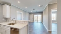 Located at 2421 Bristol Road in Warrington, PA, this thoughtfully designed 2-bedroom, 2-bathroom unit offers a clean, contemporary aesthetic throughout its well-appointed single floor. The open-concept kitchen anchors the living area, showcasing white shaker cabinetry with crown molding, striking veined quartz countertops, a peninsula with undermount sink, and a full suite of stainless steel appliances including a gas range, built-in microwave, refrigerator, and dishwasher. Recessed lighting and crown molding add a refined touch, while wood-look plank flooring flows seamlessly through the main living areas and bedrooms. Sliding glass doors lead from the living area to an outdoor space, filling the room with natural light. The spacious primary bedroom includes a dedicated closet and direct access to its own bathroom. Both bathrooms are finished with marble-style floor-to-ceiling tile, white vanities with quartz countertops, and soaking tub and shower combinations. The second bedroom features a large window with outdoor views, providing abundant natural light. Two closets and a hallway complete the functional layout, making this a well-equipped and stylish home in Bucks County.