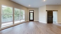 Located at 2550 Blackmon Drive in Decatur, GA, this well-designed residence offers three bedrooms and three bathrooms across a single, thoughtfully arranged floor. Light wood-style flooring flows throughout the open living areas, complemented by warm neutral tones on the walls and crisp white trim.

The kitchen is a standout feature, showcasing floor-to-ceiling white shaker cabinetry, a striking dark penny-tile backsplash, dark granite countertops, and a large center island with pendant lighting. Stainless steel appliances — including a double wall oven, microwave, and refrigerator — round out this well-equipped culinary space. A built-in wine rack adds a refined touch.

The open living room benefits from large windows that invite natural light and offer views of the surrounding greenery, with a dark-framed entry door adding a bold architectural contrast. The bedrooms are comfortably sized with the same wood-style flooring, ceiling fans, and ample natural light.

The bathrooms are finished with dark granite vanity tops, white cabinetry, and large-format tile flooring. The primary bath features a dual-sink vanity with an octagonal mirror, while secondary bathrooms include subway-tiled tub-shower combinations. A connecting hallway ties the layout together seamlessly.